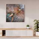 Framed artwork of birds on a wall above a wooden console table with plants.