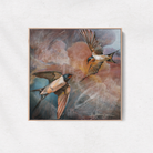 Framed artwork of two birds in flight on a white wall